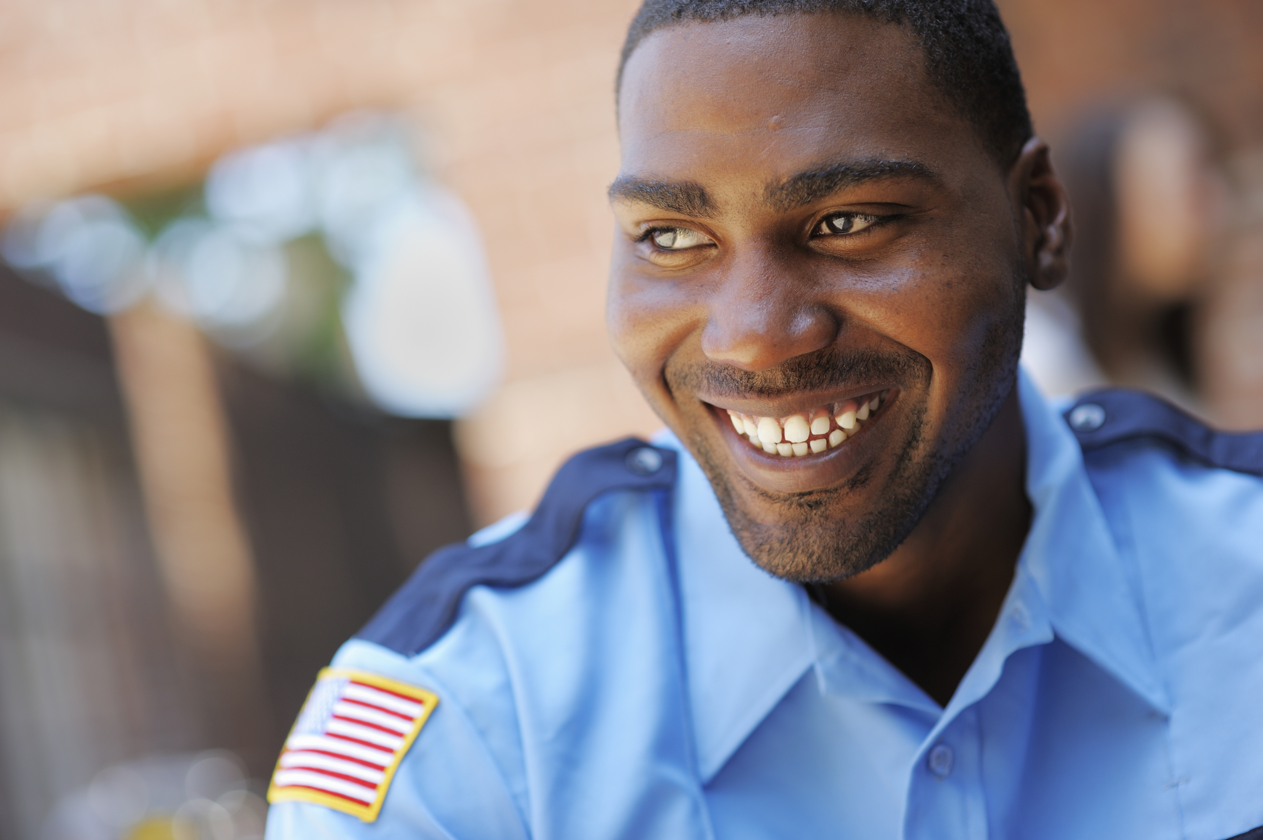 An American security or police officer smiling and happy.